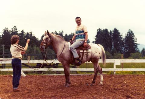 A man sitting on a large horse.